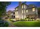 Backyard view showcasing a patio, verdant landscaping, and exterior home architecture at dusk at 5833 Wembley Dr, Douglasville, GA 30135