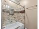 Bathroom featuring a bathtub with glass door and modern stone backsplash with decorative shower niche at 5833 Wembley Dr, Douglasville, GA 30135