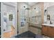 Modern bathroom featuring a glass enclosed shower with dual shower heads, black tile floor, and wood vanity at 5833 Wembley Dr, Douglasville, GA 30135