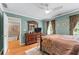 Bright bedroom with hardwood floors, ceiling fan, a large dresser, and staircase access at 5833 Wembley Dr, Douglasville, GA 30135