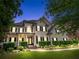 Charming two-story home at dusk features manicured lawn, lush landscaping, and inviting front porch at 5833 Wembley Dr, Douglasville, GA 30135