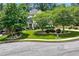 Charming two-story home featuring a beautifully landscaped front yard with mature trees and circular driveway at 5833 Wembley Dr, Douglasville, GA 30135