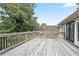 Expansive wooden deck with railing, ideal for entertaining and outdoor living, surrounded by lush trees and clear skies at 6381 Lakeview Dr, Buford, GA 30518