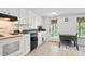 Kitchen features white cabinets, green countertops, and a black dishwasher with view to the backyard at 6381 Lakeview Dr, Buford, GA 30518