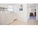 Bright laundry room with white appliances, storage cabinets, and a view into an adjacent room, complemented by patterned flooring at 6381 Lakeview Dr, Buford, GA 30518