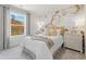 Well-lit bedroom featuring soft carpet, neutral walls, a large window, and a feature wallpaper behind the bed at 8501 Polston Place Lot 143 Pl, Douglasville, GA 30134