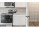 Kitchen range with stainless steel appliances, granite countertops, white cabinets, and a walk-in pantry to the right at 8501 Polston Place Lot 143 Pl, Douglasville, GA 30134