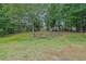Serene backyard featuring mature trees and natural rock landscaping creates a peaceful outdoor setting at 2330 Wood Creek Ct, Dacula, GA 30019