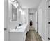 Well-lit bathroom with double sinks and wood-look flooring at 2330 Wood Creek Ct, Dacula, GA 30019