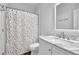Bright bathroom featuring marble countertop and a colorful shower curtain at 2330 Wood Creek Ct, Dacula, GA 30019