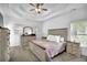 Bedroom with a tray ceiling, bright windows, and neutral-toned furniture at 2330 Wood Creek Ct, Dacula, GA 30019