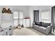 Well-lit bedroom with cozy sofa, crib, and neutral decor at 2330 Wood Creek Ct, Dacula, GA 30019