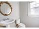 Powder room featuring pedestal sink, ornate mirror and window for natural light at 222 Chadmore Ln, Tyrone, GA 30290