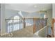 Hallway with decorative railing looking down into the main floor and a large arched window at 222 Chadmore Ln, Tyrone, GA 30290