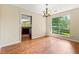 Inviting dining room with wood floors and a chandelier, next to a large window bringing in natural light at 2431 Rosedale Creek Dr, Snellville, GA 30078