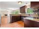Open-concept kitchen with wood floors, dark cabinets, and granite countertops, seamlessly connecting to the living area at 2431 Rosedale Creek Dr, Snellville, GA 30078