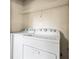 Well-lit laundry room with washer, dryer and storage shelf at 2431 Rosedale Creek Dr, Snellville, GA 30078