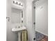 Half-bathroom featuring a stylish mirror, pedestal sink, and clean design at 2964 Greyhawk Ln, Cumming, GA 30040
