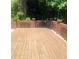 Large wooden deck surrounded by brick walls and lush greenery, perfect for outdoor entertaining at 3233 Rockmill Dr, Ellenwood, GA 30294