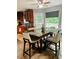 Dining room with large wood table, seating for six, window overlooking the backyard, and tile floors at 3233 Rockmill Dr, Ellenwood, GA 30294