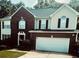Charming two-story home with a brick and siding facade, attached two car garage, and manicured front lawn at 3233 Rockmill Dr, Ellenwood, GA 30294