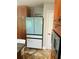 The kitchen offers a spacious refrigerator and wooden cabinetry with a door to another room in view at 3233 Rockmill Dr, Ellenwood, GA 30294