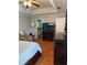 Comfortable main bedroom with sitting area, tray ceilings, wood floors and view to bathroom at 3233 Rockmill Dr, Ellenwood, GA 30294