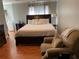 Spacious primary bedroom with a comfortable king bed, warm wood floors and large side tables at 3233 Rockmill Dr, Ellenwood, GA 30294