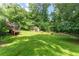 Scenic backyard showcasing lush greenery, a charming outbuilding, and a tiered deck perfect for outdoor living at 5435 Chelsen Wood Dr, Duluth, GA 30097