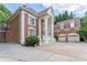 An inviting side view of a distinguished brick home, showcasing its architectural details and three-car garage at 5435 Chelsen Wood Dr, Duluth, GA 30097