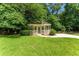 Quaint backyard gazebo featuring white railings and a concrete path, nestled among lush green trees and lawn at 5435 Chelsen Wood Dr, Duluth, GA 30097