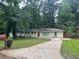 Charming one-story home with a well-manicured front lawn and a long concrete driveway at 1413 David Cir, Decatur, GA 30032