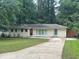 Charming one-story home with a well-manicured front lawn and a long concrete driveway at 1413 David Cir, Decatur, GA 30032