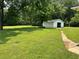 Expansive backyard with lush greenery and detached garage or shed at 3561 Clay Rd, Austell, GA 30106