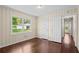 Bedroom featuring wood floors, paneled walls, and natural light streaming through the windows at 3561 Clay Rd, Austell, GA 30106