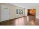 Bright living room with hardwood floors, a classic white door, and views into a wood-paneled den at 3561 Clay Rd, Austell, GA 30106