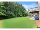Picturesque backyard with lush green grass, mature trees and partial view of the house at 4130 Millbrook Ct, Suwanee, GA 30024