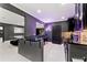 Basement bar with black marble counter, serving bar seating, neon lights, and black cabinetry at 4130 Millbrook Ct, Suwanee, GA 30024