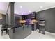 Basement bar featuring black marble counters, serving bar seating, lighting, and an arcade game at 4130 Millbrook Ct, Suwanee, GA 30024