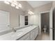 Bathroom featuring double sinks, decorative mirror, and a partially visible shower at 4130 Millbrook Ct, Suwanee, GA 30024