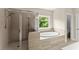 The bathroom features a separate glass shower and a tiled soaking tub near a sunlit window at 4130 Millbrook Ct, Suwanee, GA 30024