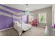 Bright bedroom with modern decor, playful purple accent wall, and carpeted floors, illuminated by two windows at 4130 Millbrook Ct, Suwanee, GA 30024