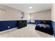 Bedroom has a blue accent wall with a Braves-themed bedspread and a basketball hoop on the wall at 4130 Millbrook Ct, Suwanee, GA 30024