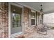 Inviting front porch featuring brick flooring, seating, and decorative lighting for relaxing outdoor enjoyment at 4130 Millbrook Ct, Suwanee, GA 30024