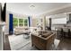 Open-concept living room features hardwood floors, a fireplace, and large windows with backyard views at 4130 Millbrook Ct, Suwanee, GA 30024