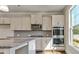 Modern kitchen features gray cabinets, stainless steel appliances, granite counters and natural light at 8513 Polston Lot 137 Pl, Douglasville, GA 30134