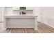 Contemporary kitchen island with white cabinets, breakfast bar, and an open layout at 8513 Polston Lot 137 Pl, Douglasville, GA 30134