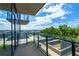 Balcony featuring a concrete floor and glass railing overlooking lush trees and a view on a partly cloudy day at 788 W Marietta Nw St # 212, Atlanta, GA 30318