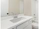 Modern bathroom features a white vanity, large mirror, toilet, and shower-tub combo at 148 Palm St, Holly Springs, GA 30115