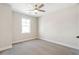 Neutral bedroom features carpeted floors, a ceiling fan, and a bright window at 148 Palm St, Holly Springs, GA 30115